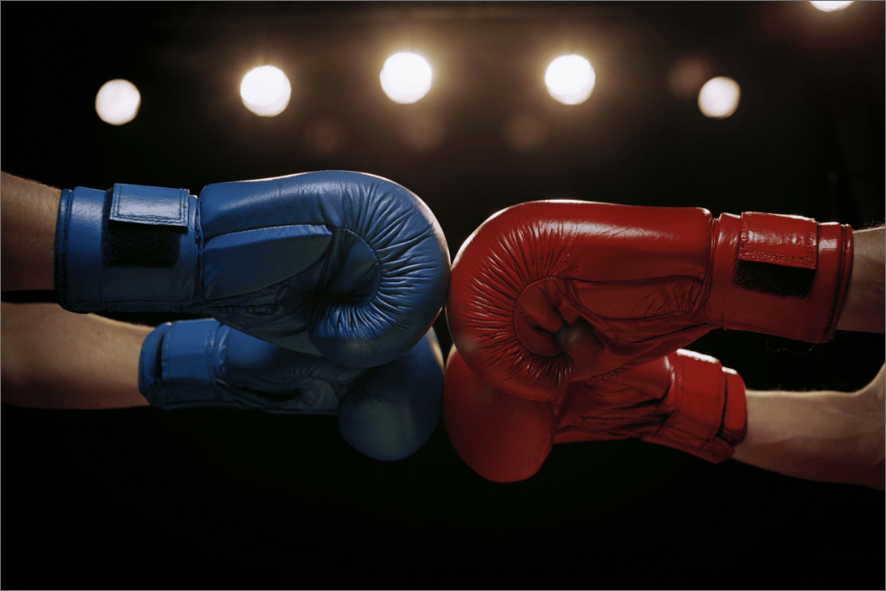 Two boxing mitts fist bumping.